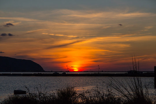 sunset at lefkas lagoon in greece with dike and water