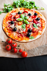 Hot pizza slice with Pepperoni, cheese, mozzarella, herbs  and tomato  on a rustic background  close up. Food ingredients and spices