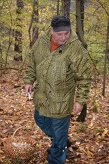 в осеннем лесу мужчина собирает грибы 