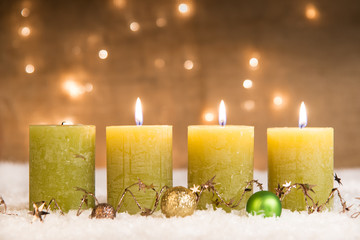 grüne adventskerzen im schnee zum 3. advent