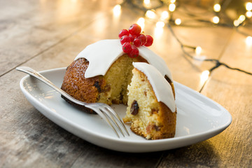 Christmas pudding and christmas light on wooden table
