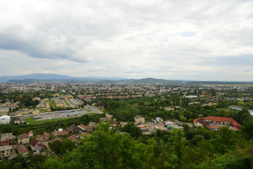 Fototapeta na wymiar Aerial view of city buildings, green summer landscape, mountains, village
