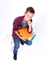 tired schoolboy European appearance in shirt and jeans sitting o