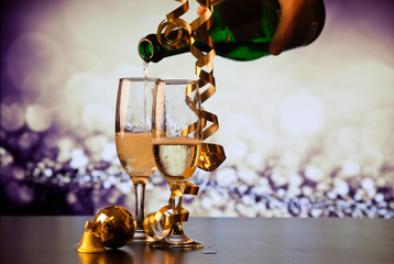 two champagne glasses with ribbons against holiday lights and fireworks - New Year celebrations