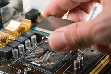 Fototapeta na wymiar Technician plug in CPU microprocessor to motherboard socket