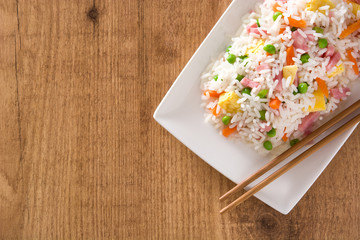 Fototapeta na wymiar Chinese fried rice with vegetables and omelette on wooden table.Top view 