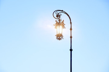 Fototapeta na wymiar Old antique aged beautiful street lamp lantern light on a clear sky