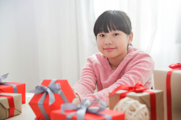 Asian girl smiling and holding a red gift box.