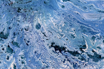 Marbled blue abstract background with golden sequins. Liquid marble ink pattern.