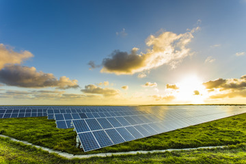 Solar panels at sunrise with cloudy sky in Normandy, France. Solar energy, modern electric power production technology, renewable energy concept. Environmentally friendly electricity production - 179844111
