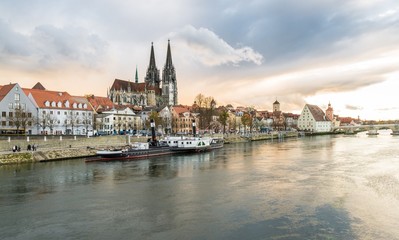 Naklejka na ściany i meble Regensburg im morgen Licht an einem Sommertag mit Promenade und Dom und Steinerne Brücke