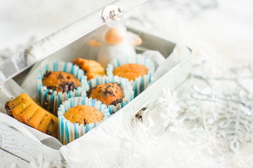 Christmas pumpkin carrot spicy muffins with chocolate in gift iron box. A little white angel is also in the box Original Christmas card. Place for your text and congratulations