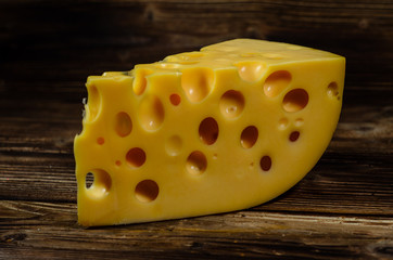 Piece of cheese on wooden table