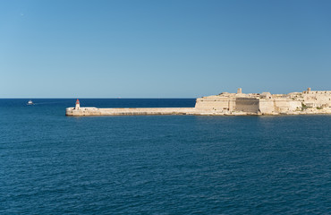Fototapeta na wymiar Fort Ricasoli and lighthouse at entrance of the Grand Harbour (Malta)