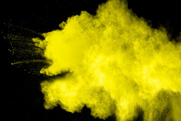abstract yellow powder explosion on  black background.abstract yellow powder splatted on black...