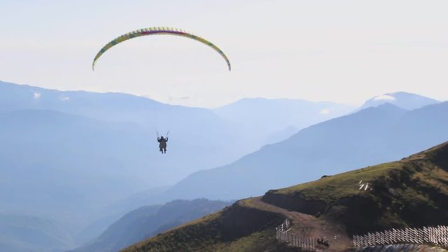 A paragliding soaring along a ridge line gains lift.