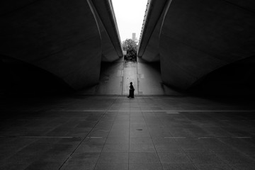 silhouette of a walking woman under the bridge in Singapore - black and white, high contrast