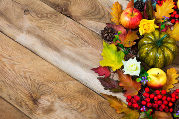 Fall rustic background with colorful fall leaves, green pumpkin, apple, lilac flowers and red...
