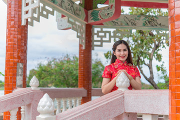 happy Chinese new year. Asian woman wearing traditional Cheongsam clothes with red envelope  portrait outdoor