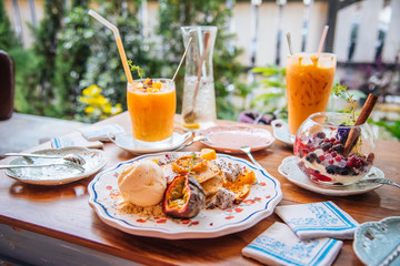 Sweet Pancakes with honey and vanilla ice cream Fruit with Orange focus on pancake