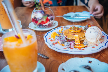 Sweet Pancakes with honey and vanilla ice cream Fruit with Orange focus on pancake