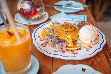 Sweet Pancakes with honey and vanilla ice cream Fruit with Orange focus on pancake