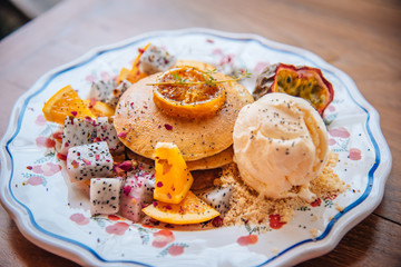 Sweet Pancakes with honey and vanilla ice cream Fruit with Orange focus on pancake