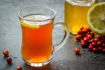 Hot fall tea with lemon, honey and berries. Homemade cold and flu remedies. Selective focus, close up, copy space.