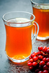 Hot fall cosy tea with berries and lemon on concrete background. Selective focus, close up, copy space.