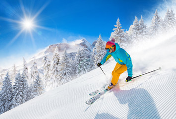 Skier skiing downhill in high mountains