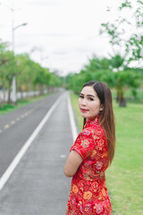 Naklejka premium happy Chinese new year. Asian woman wearing traditional Cheongsam clothes portrait outdoor