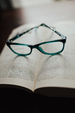 Teal glasses sitting on book