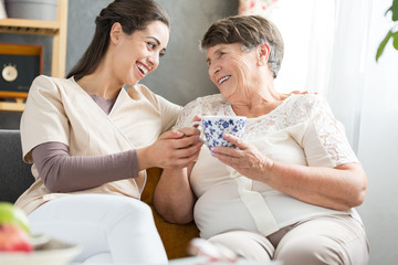 Obraz na płótnie Canvas Nurse and elderly lady laughing