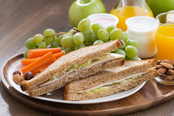 lunch with sandwiches, drinks and fresh fruit on wooden table