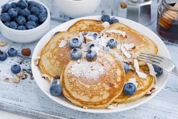 pancakes with fresh blueberries and honey for breakfast on wooden table