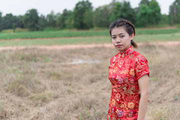 happy Chinese new year. Asian woman wearing traditional Cheongsam clothes portrait outdoor