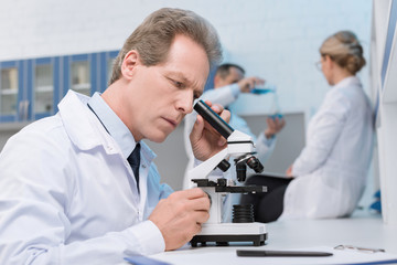 Naklejka na ściany i meble scientist working with microscope