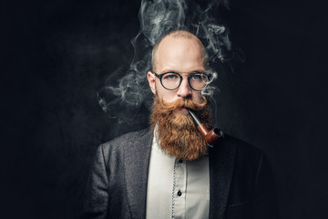 A man smoking pipe over grey background.