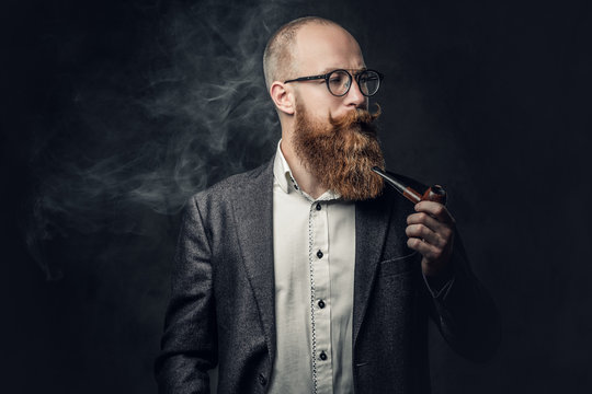 A man smoking pipe over grey background.