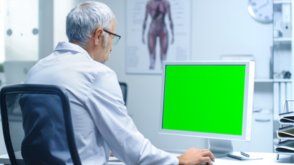 Senior Male Laboratory Researcher Working with Green Screen on His Personal Computer. Great for...