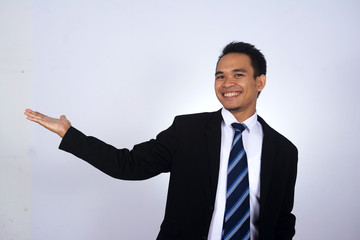 Asian businessman showing something with open hand, isolated in white background