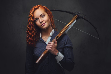 Redhead female  holds crossbow.