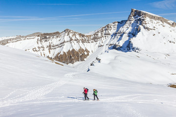 Senior couple is snowshoe hiking in alpine winter mountains. Bavaria, Germany.