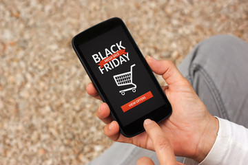 Hands holding smart phone with Black Friday concept on screen. All screen content is designed by me