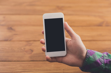 Man using smartphone at wooden background, close up