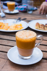 Cup of milk tea with roti on the table.