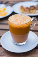Cup of milk tea with roti on the table.
