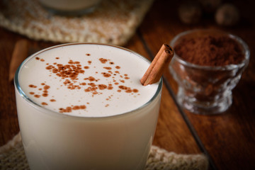 Eggnog houmemade with cinnamon and kakao for Christmas and winter holidays or wooden broun backgrounds