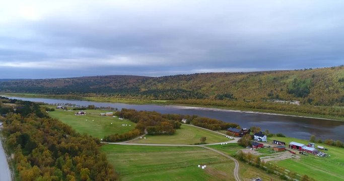Autumn color landscape, Cinema 4k aerial pan view of mountains and fields, full of different colors, near tenojoki river, on a cloudy day, in Lapland, Finland