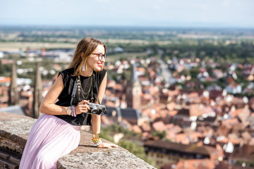 Portrait of a young woman tourist enjoying aerial view on the Obernai village in Alsace in north-eastern France